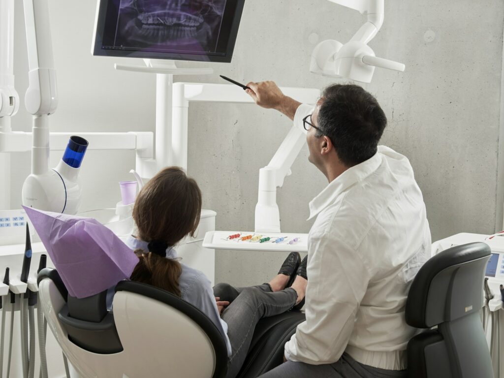 Dentiste montrant une radiographie à une patiente lors d'un check dentaire de rentrée à Athis-Mons